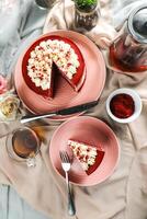 Premium Red Velvet cake and slice include cream, sugar with fork, cup of coffee and pot served on board isolated on napkin top view of cafe food photo