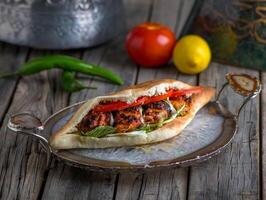 sheesh taouk sandwich served in a dish side view on wooden table background photo