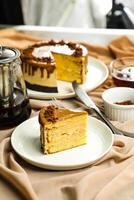 Salted Caramel Blondie cake slice include chocolate cream, sugar with fork, cup of coffee and pot served plate isolated on napkin side view of cafe food photo