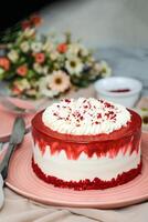 Premium Red Velvet cake include cream, sugar with fork, knife and flowers served in plate isolated on napkin side view of cafe food photo