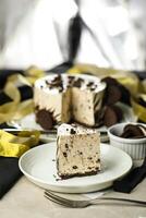 Oreo Cheesecake slice include chocolate, cream, sugar with fork and flowers served in plate isolated on napkin side view of cafe food photo
