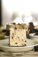 Oreo Cheesecake slice include chocolate, cream, sugar with fork and flowers served in plate isolated on napkin side view of cafe food photo