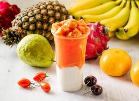 papaya milk with raw fruits served in disposable glass isolated on background top view taiwan food photo