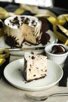 Oreo Cheesecake slice include chocolate, cream, sugar with fork and flowers served in plate isolated on napkin side view of cafe food photo