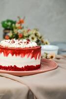 Premium Red Velvet cake include cream, sugar with fork, knife and flowers served in plate isolated on napkin side view of cafe food photo