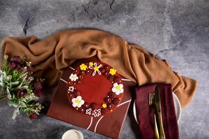 chocolate dorado cordón pastel con Rosa flores, cuchillo y tenedor servido en tablero aislado en servilleta parte superior ver de café horneado comida foto