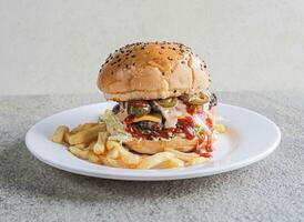 Spicy beef jalapeno burger with fries served in a dish isolated on grey background side view of fast food photo