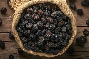 AI generated Natural sweetness Black raisins in burlap bag on rustic background photo