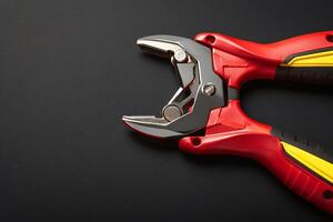 AI generated Vibrant tool contrast Red pliers on a black background, copy space photo