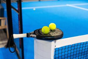 Paddle tennis racket, ball and net on the court photo