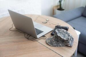 military uniform weapons and laptop on the table photo