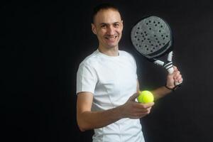 padel tenis jugador con raqueta en manos. paleta tenis, en un negro antecedentes. foto