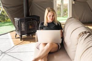 Image of young pleased happy cheerful cute beautiful business woman using laptop computer listening photo