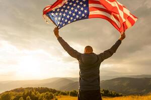 Young man proudly waving the American flag at sunset photo