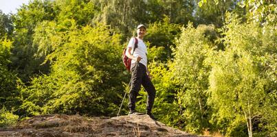 man hand holding hiking pole with green bokeh background and copy space. Summer activity for adventure person concept. photo