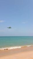 The airplane landing over tropical beach with turquoise sea in Phuket, Thailand video