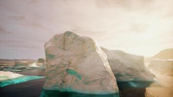 A large iceberg sitting on top of a beach next to the ocean video