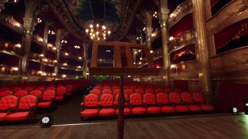 An empty theater with red seats and chandeliers video