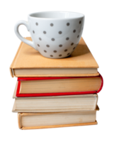 Empty dotted coffee cup placed on top of a pile of old books. png