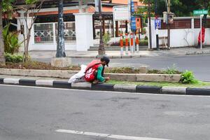 a city janitor who is mowing weeds photo