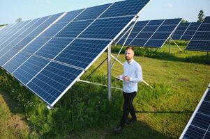 Young architect standing by solar panels photo