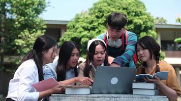 A group of friends work together on assignments and study sessions, helping each other with homework and research outside their university buildings. video