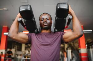 Handsome young African American man working out at the gym photo