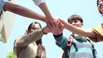 Young happy people put their hands together. video