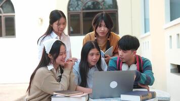 A group of friends work together on assignments and study sessions, helping each other with homework and research outside their university buildings. video