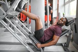 africano americano joven hombre haciendo rutina de ejercicio a el gimnasio foto