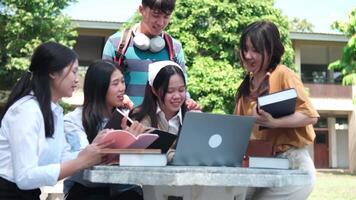 A group of friends work together on assignments and study sessions, helping each other with homework and research outside their university buildings. video