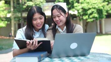 A group of friends work together on assignments and study sessions, helping each other with homework and research outside their university buildings. video