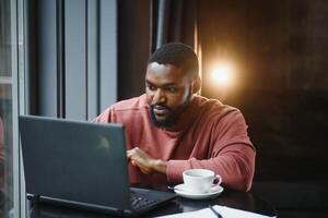 African american man working on laptop in a cafe. photo