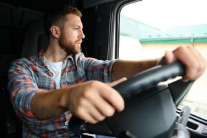 Side view of professional driver behind the wheel in truck's cabin. photo