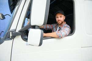 Side view of professional driver behind the wheel in truck's cabin. photo