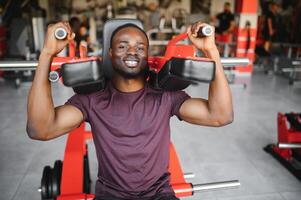 Handsome young African American man working out at the gym photo