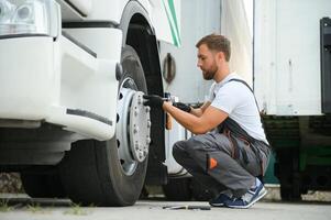 Caucasian Professional Truck Mechanic Rebuilding Heavy Duty Truck Diesel Engine. Automotive Industry Theme. photo