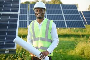 African american technician check the maintenance of the solar panels. Black man engineer at solar station. photo