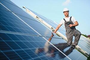 masculino trabajador en uniforme al aire libre con solar baterías a soleado día. foto