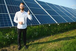 Young architect standing by solar panels photo