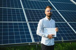 Young architect standing by solar panels photo