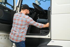 Caucasian Male Truck Driver Stepping Out Of Vehicle At Rest Stop. photo