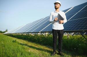 Young architect standing by solar panels photo