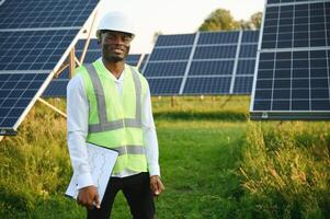 African american technician check the maintenance of the solar panels. Black man engineer at solar station. photo