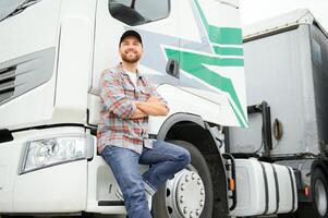 retrato de joven caucásico barbado camionero en pie por su camión vehículo. transporte servicio. camión conductor trabajo. foto