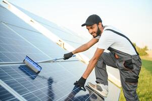 Indian worker cleaning solar panels. photo