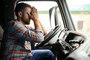 Young truck diver feeling tired and yawning during the ride. photo