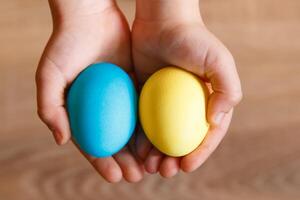 Paint eggs for Easter, bright Easter holiday, children paint eggs, colored eggs in a basket, colored eggs on a stand, Holiday background photo