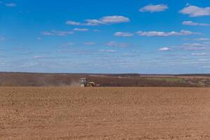 tractor plows the field, field in spring, tractor on the field photo