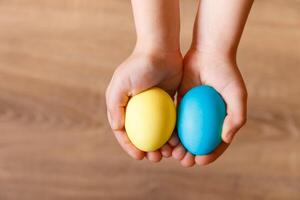 Paint eggs for Easter, bright Easter holiday, children paint eggs, colored eggs in a basket, colored eggs on a stand, Holiday background photo